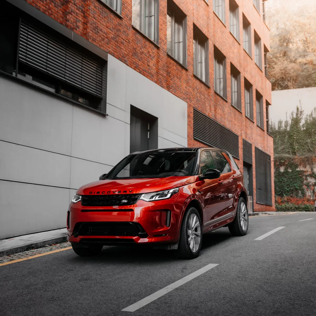 A red SUV parked outside a brick building